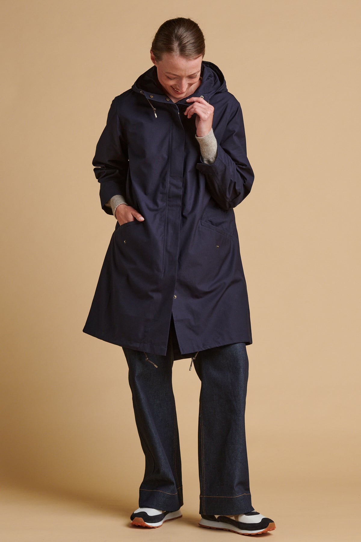Female wearing long parka coat in navy.