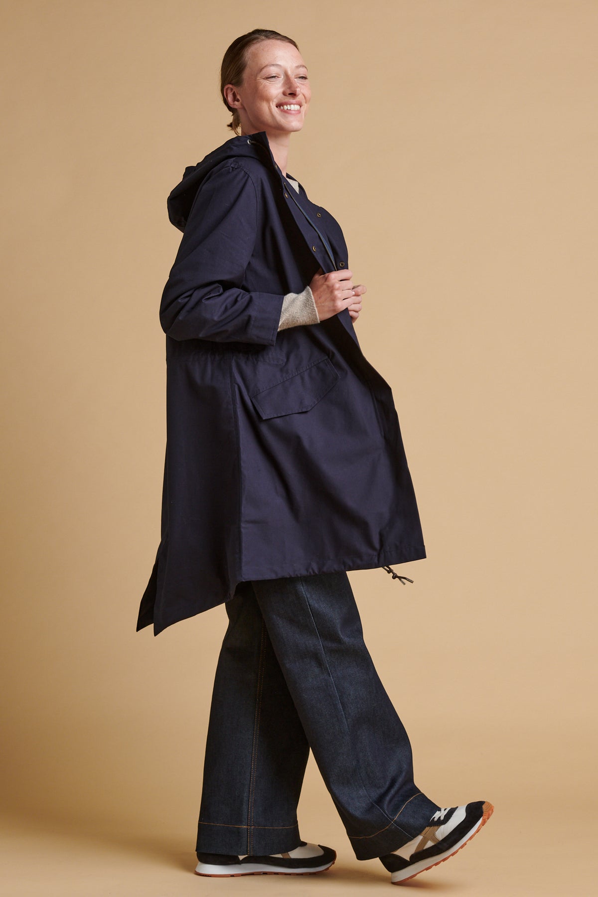 Female wearing long parka coat in navy.