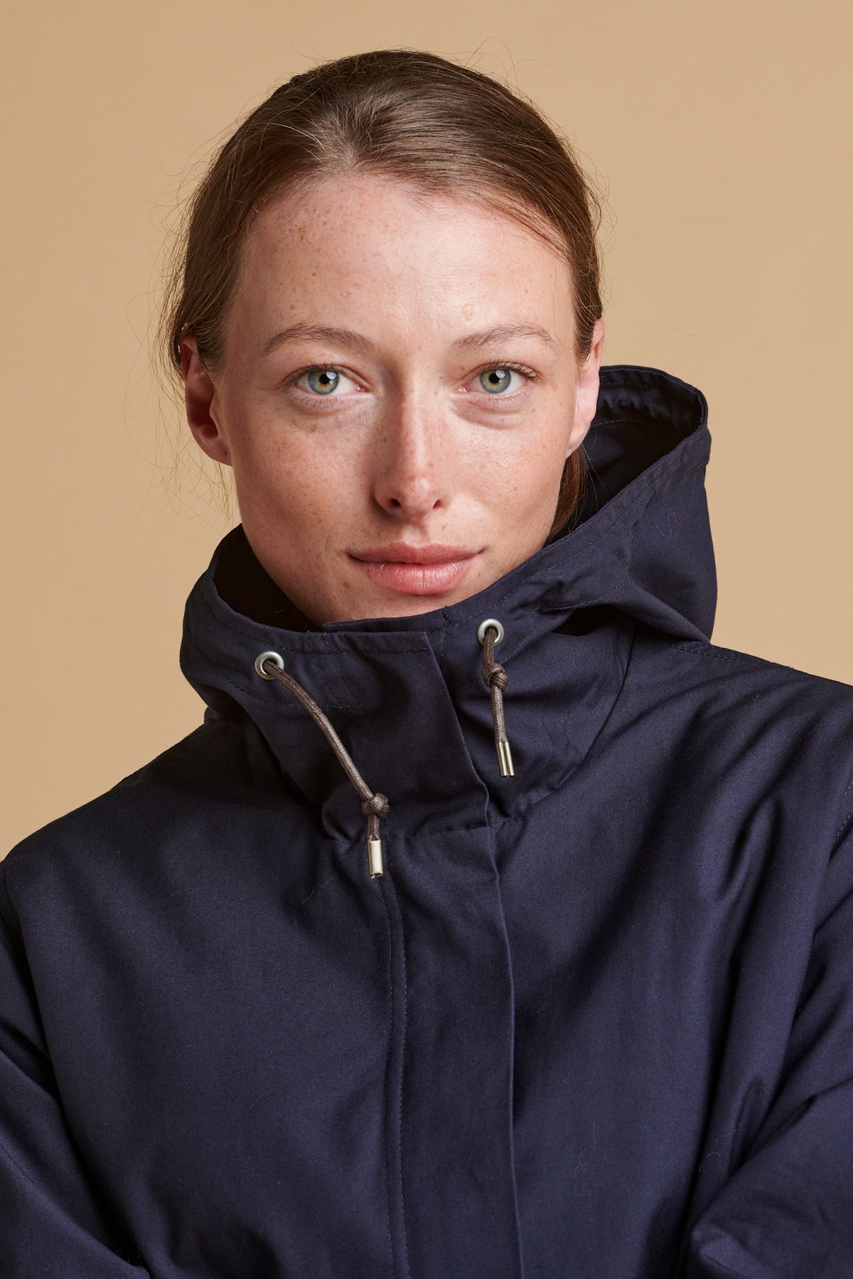 Portrait of female wearing long parka coat in navy.