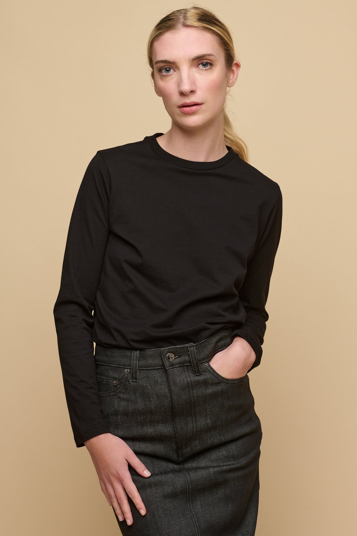 Thigh up image of the front of female wearing long sleeve t shirt in black