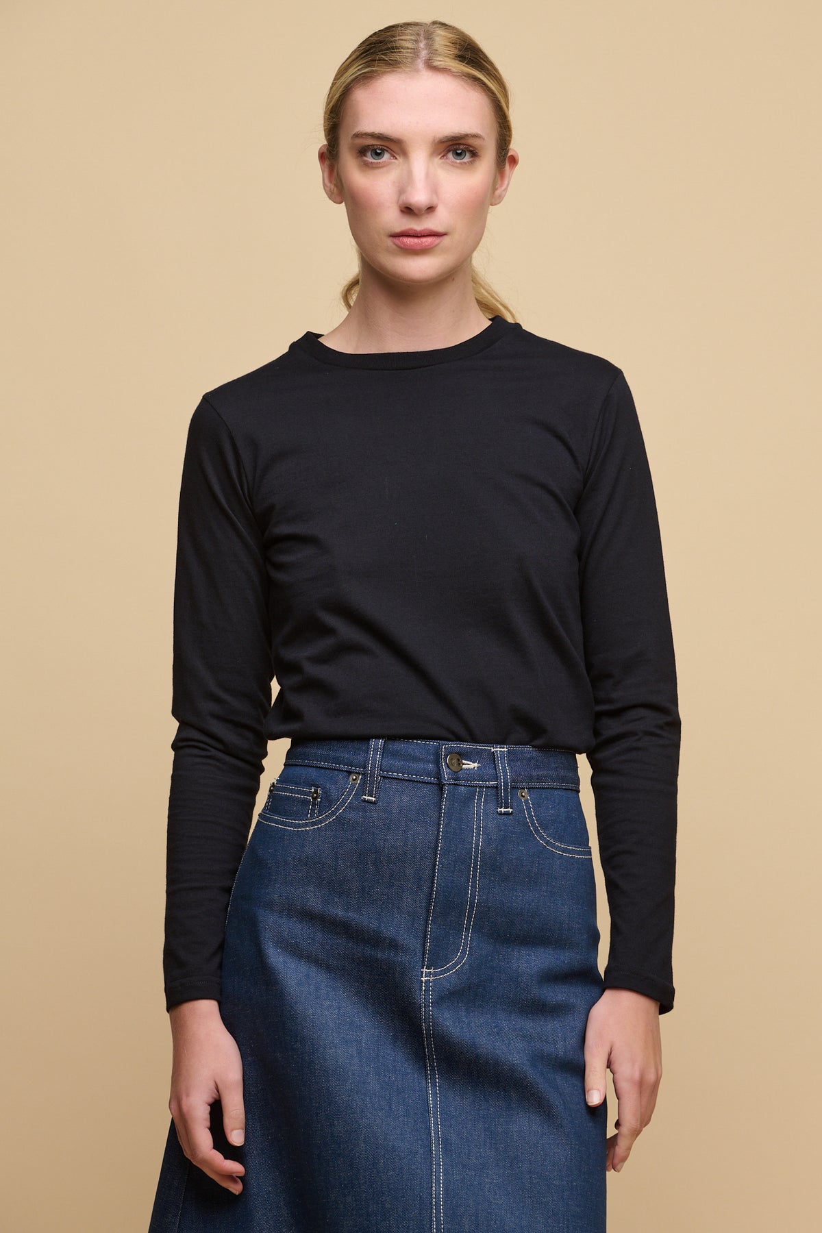 Image of female wearing long sleeve crew neck t shirt in navy tucked into Bobbie denim midi skirt in blue