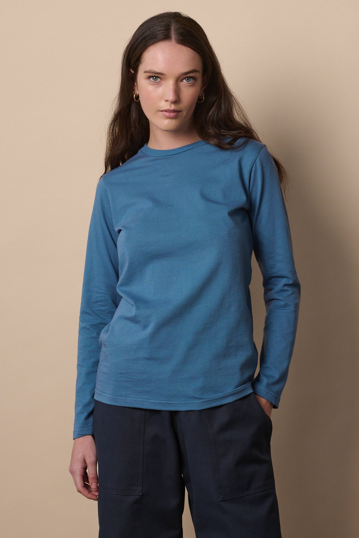 Thigh up image of female wearing long sleeve RAF blue t shirt