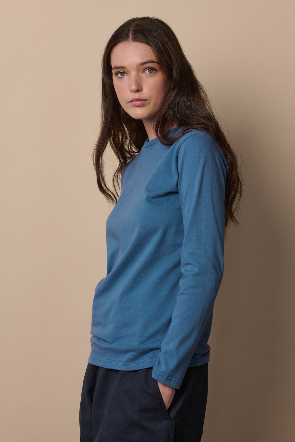 Thigh up image of brunette female wearing long sleeve t shirt in RAF blue