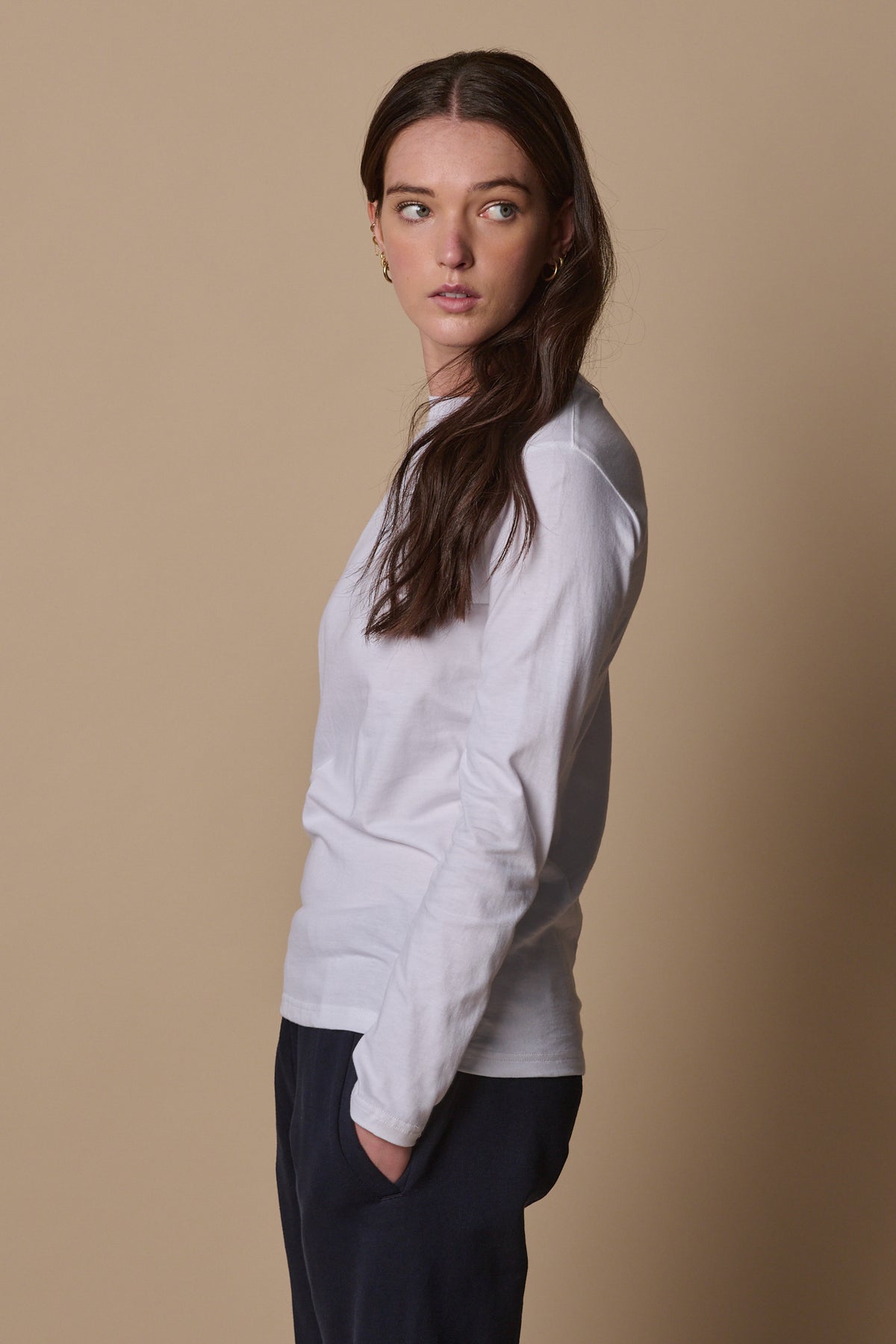 
            Female with long brown hair wearing long sleeve t shirt in white