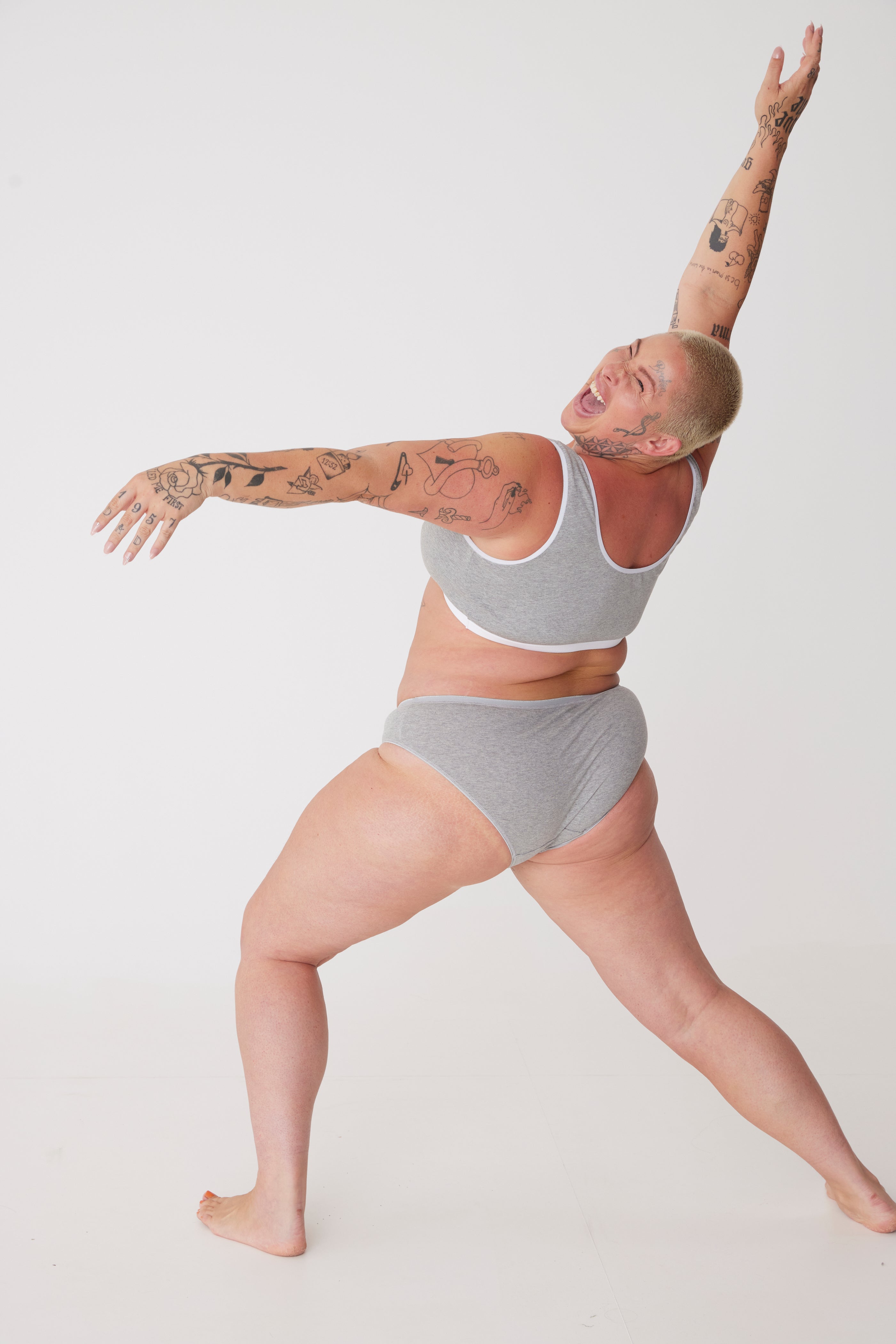 plus size, white female wearing grey low rise brief in expressive pose