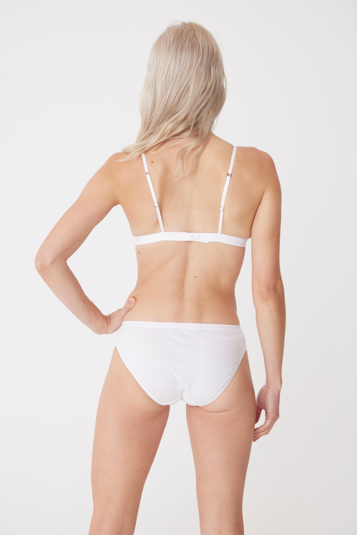 white female wearing white low rise brief back thigh up