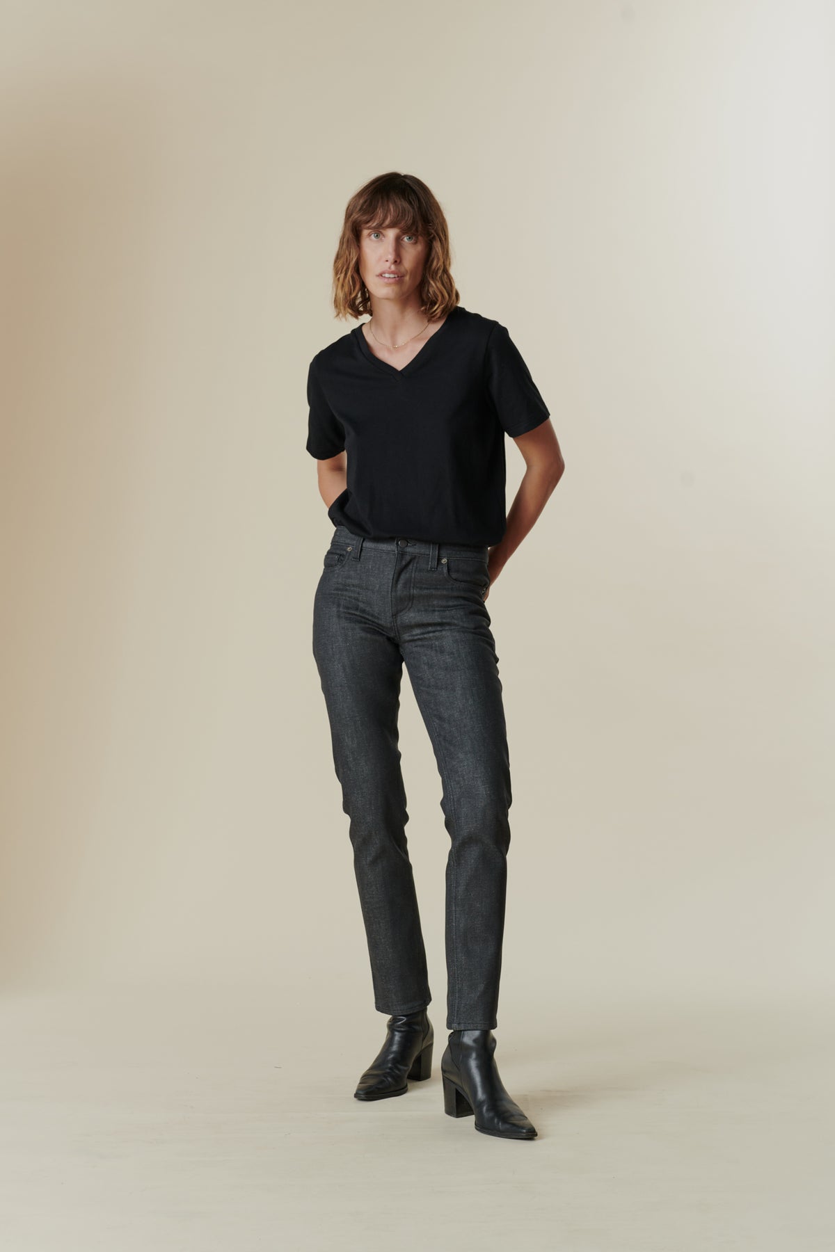 Full body image of female wearing mid rise straight leg jeans in black