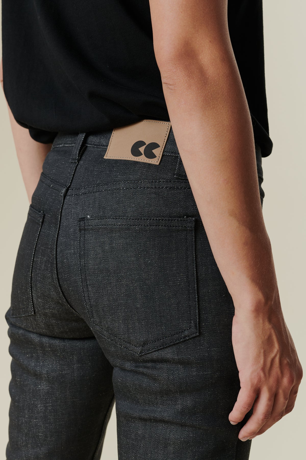 Back pocket detail image of female wearing mid rise straight leg jeans in black