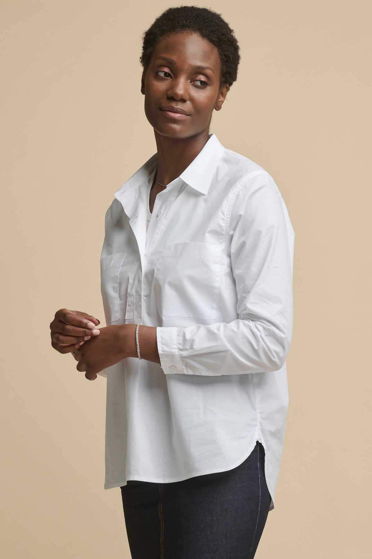 
            Thigh up image of female wearing Olivia half placket lightweight cotton shirt in white paired worn over racer back vest in white