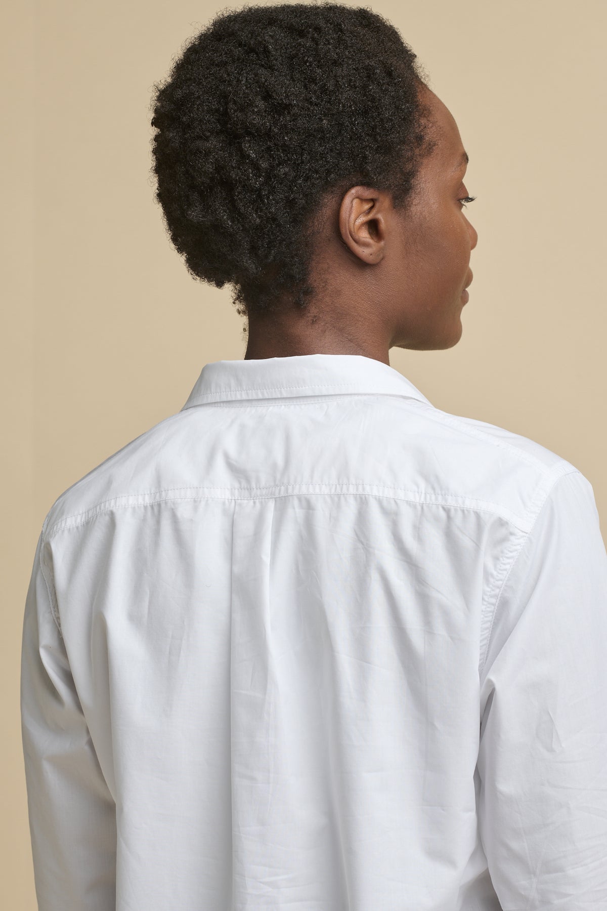 
            Close up of the back of female wearing Olivia half placket lightweight shirt in white, back pleat detail