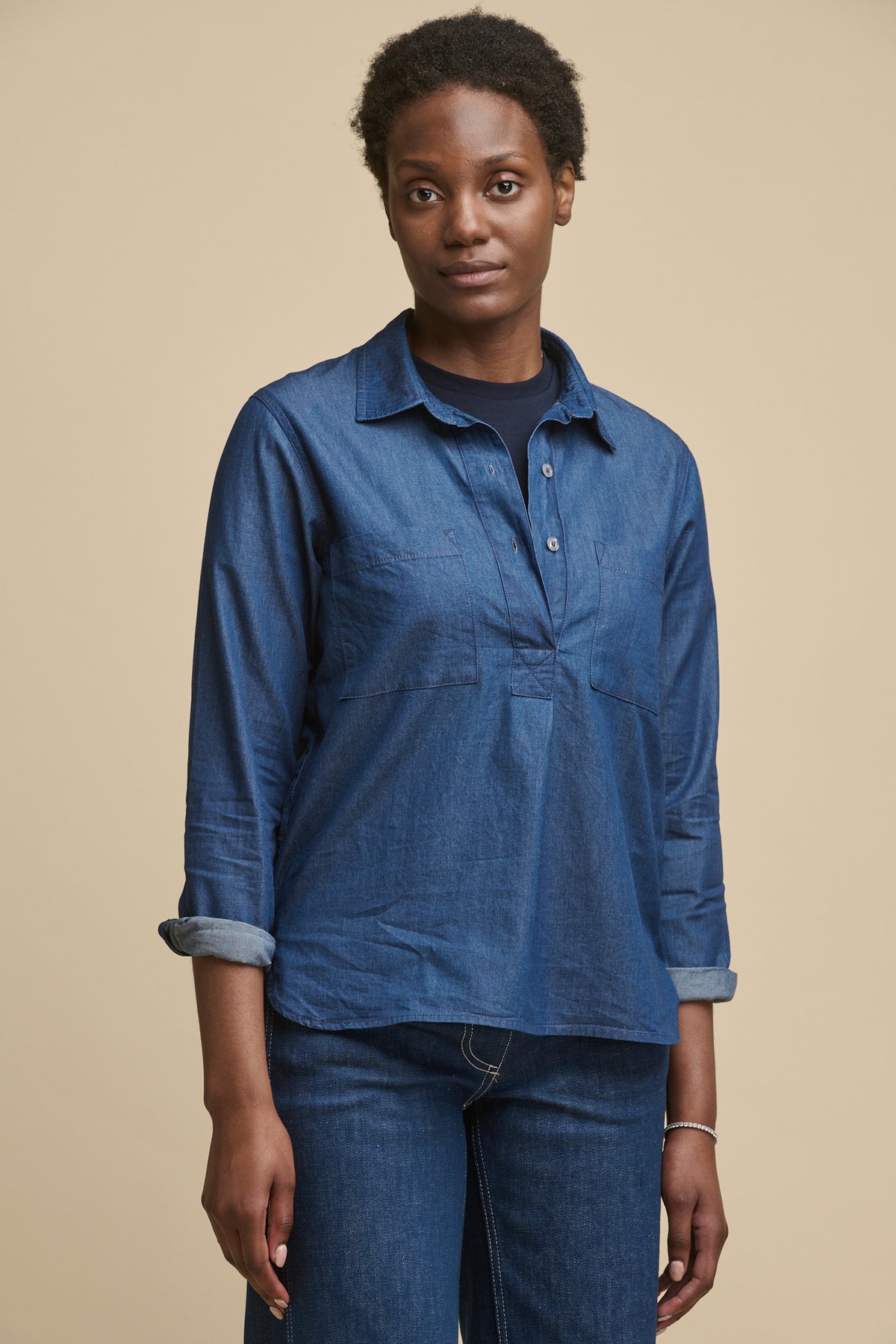 
            Thigh up image of black female wearing Olivia half placket denim shirt in indigo with the sleeves rolled up, worn over short sleeve t shirt in navy  