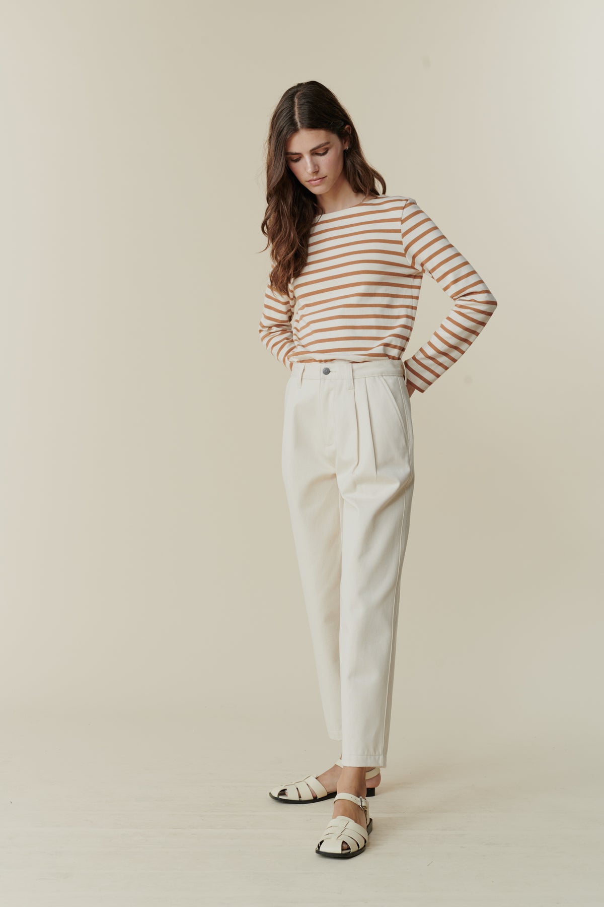 Full body front image of white female wearing women's pleated jeans in ecru