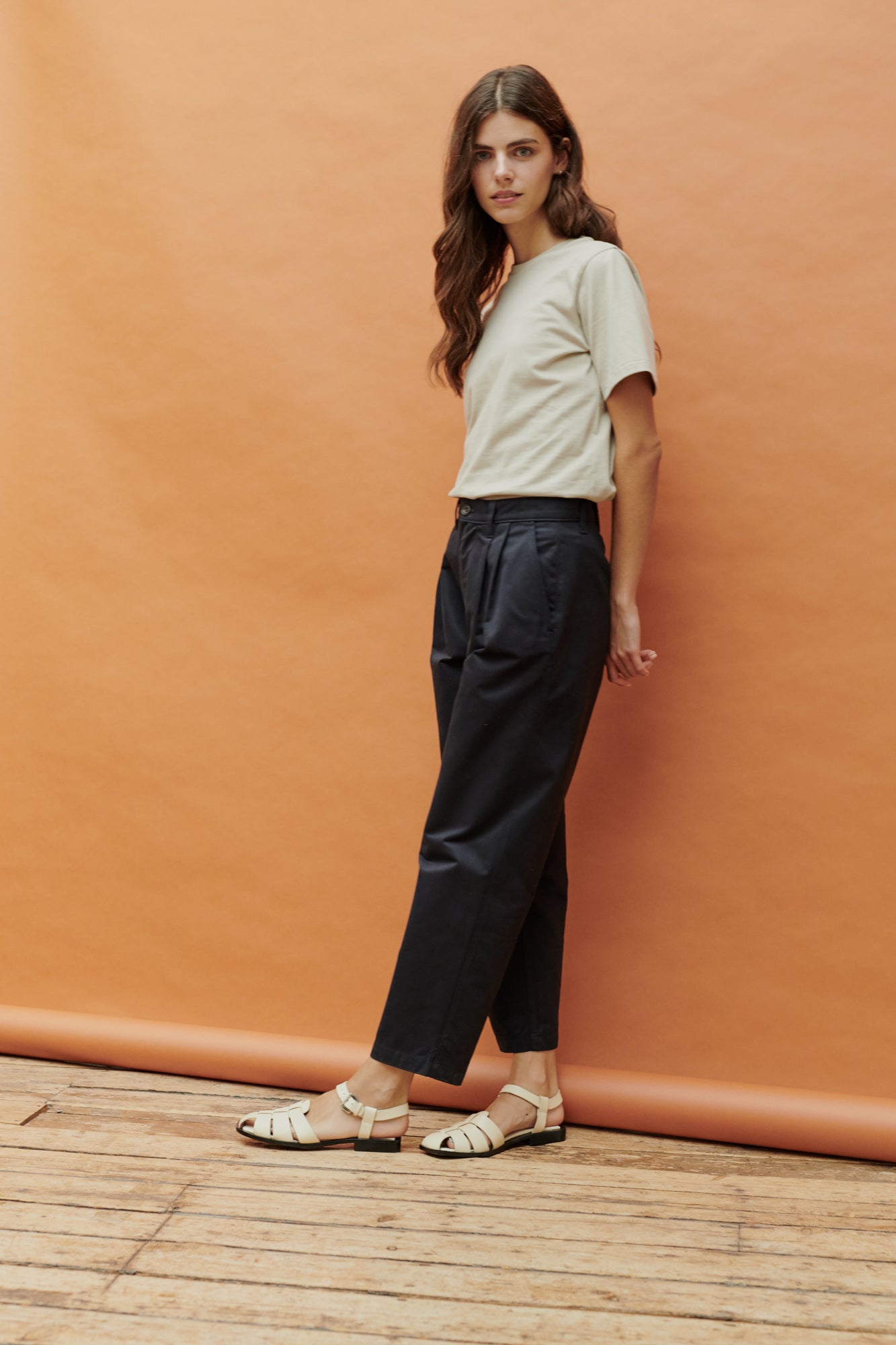Full body image of female wearing pleated jeans in navy 