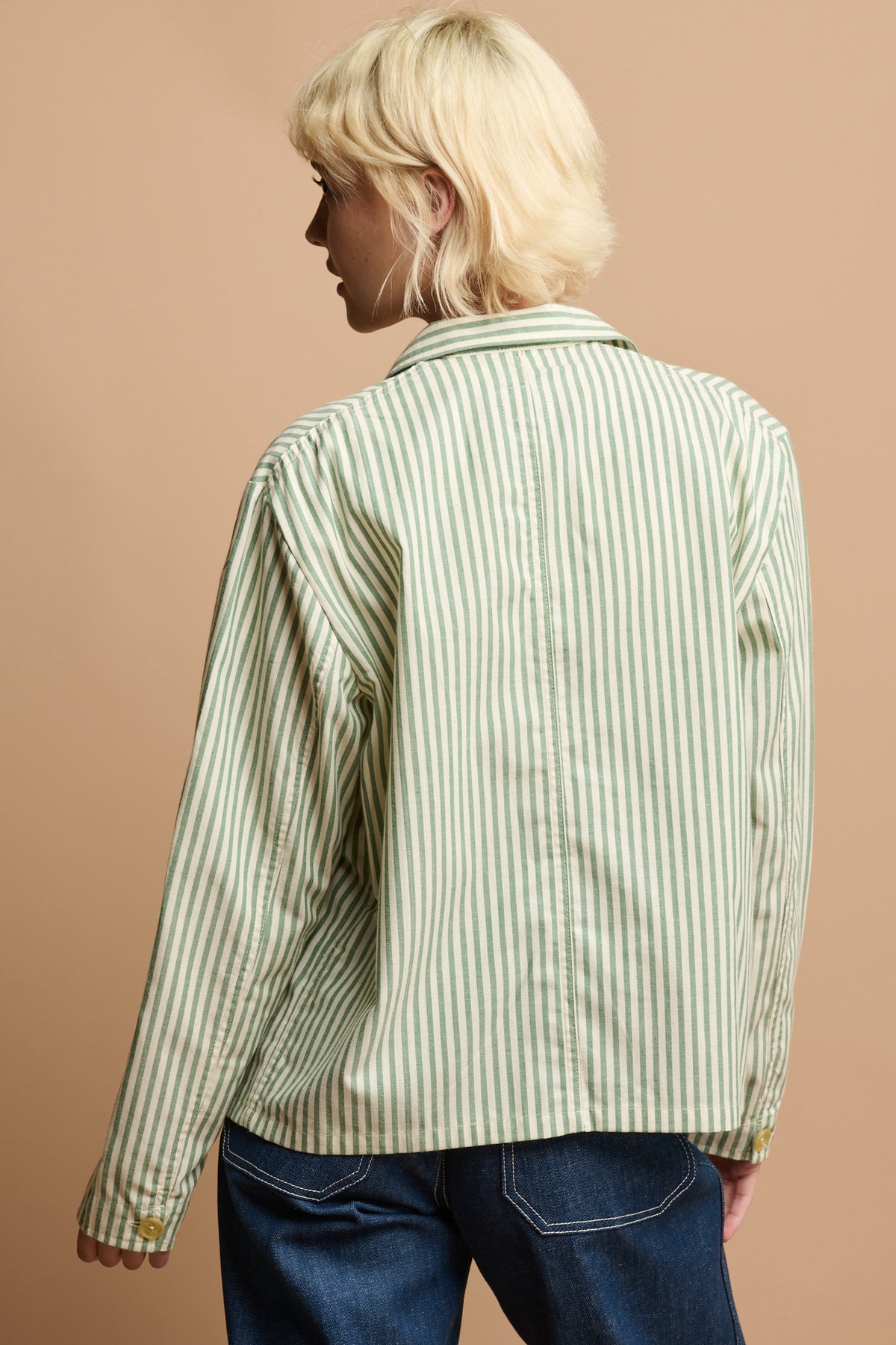 
            Thigh up of the back of female wearing green and white stripe shirt 