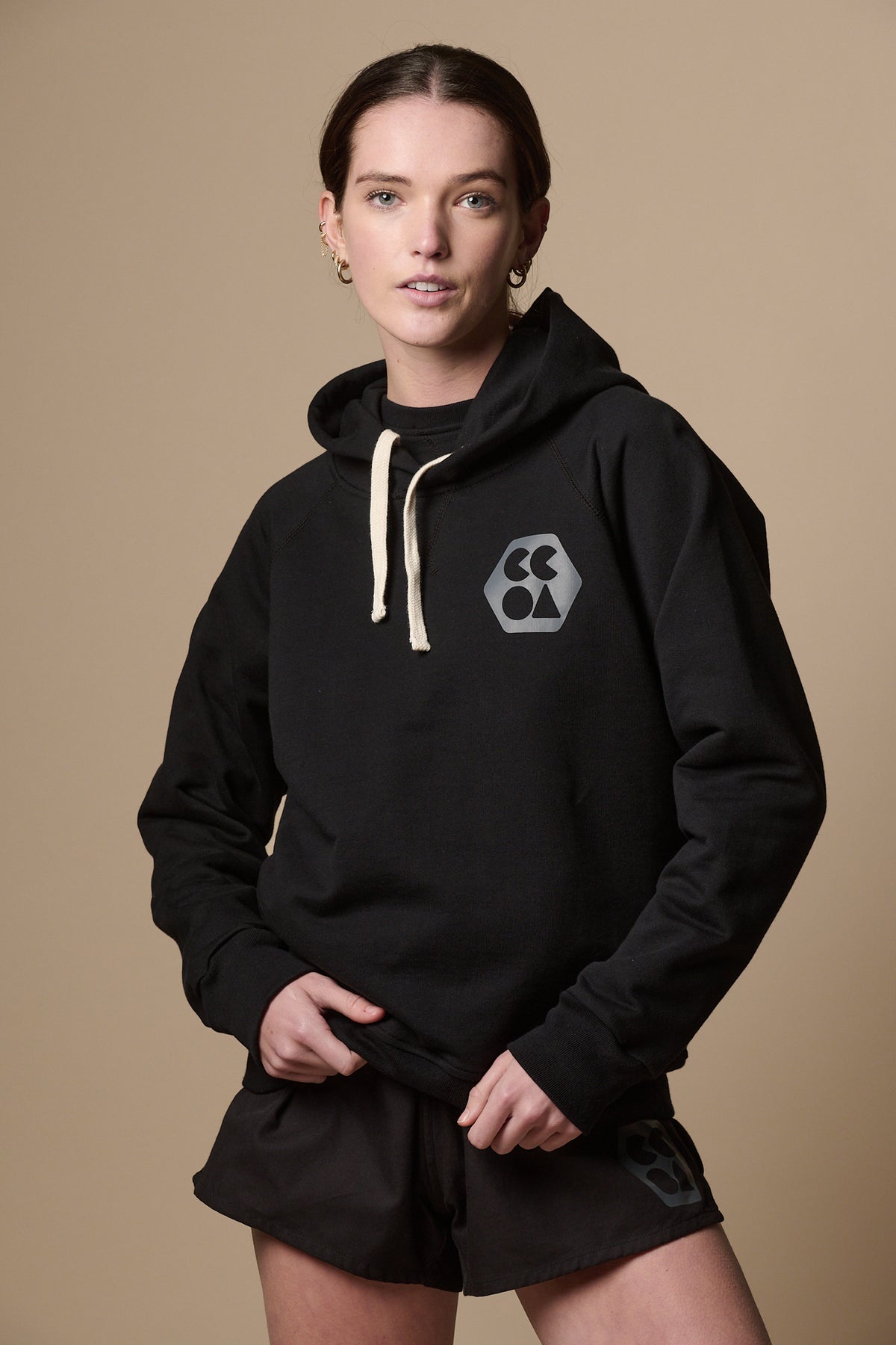 
            Thigh up image of the front of female wearing raglan hooded sweatshirt plastic free in black