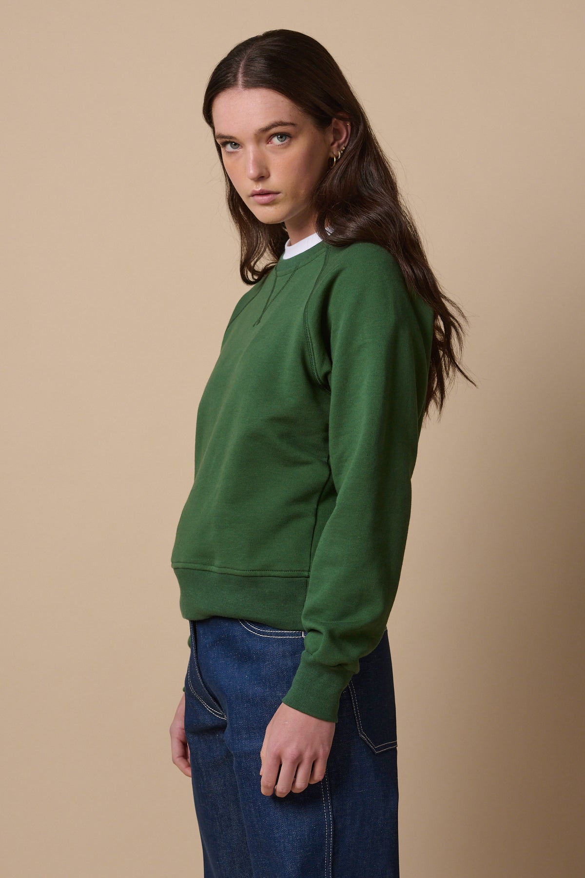 Side of female wearing raglan sweatshirt in bottle green