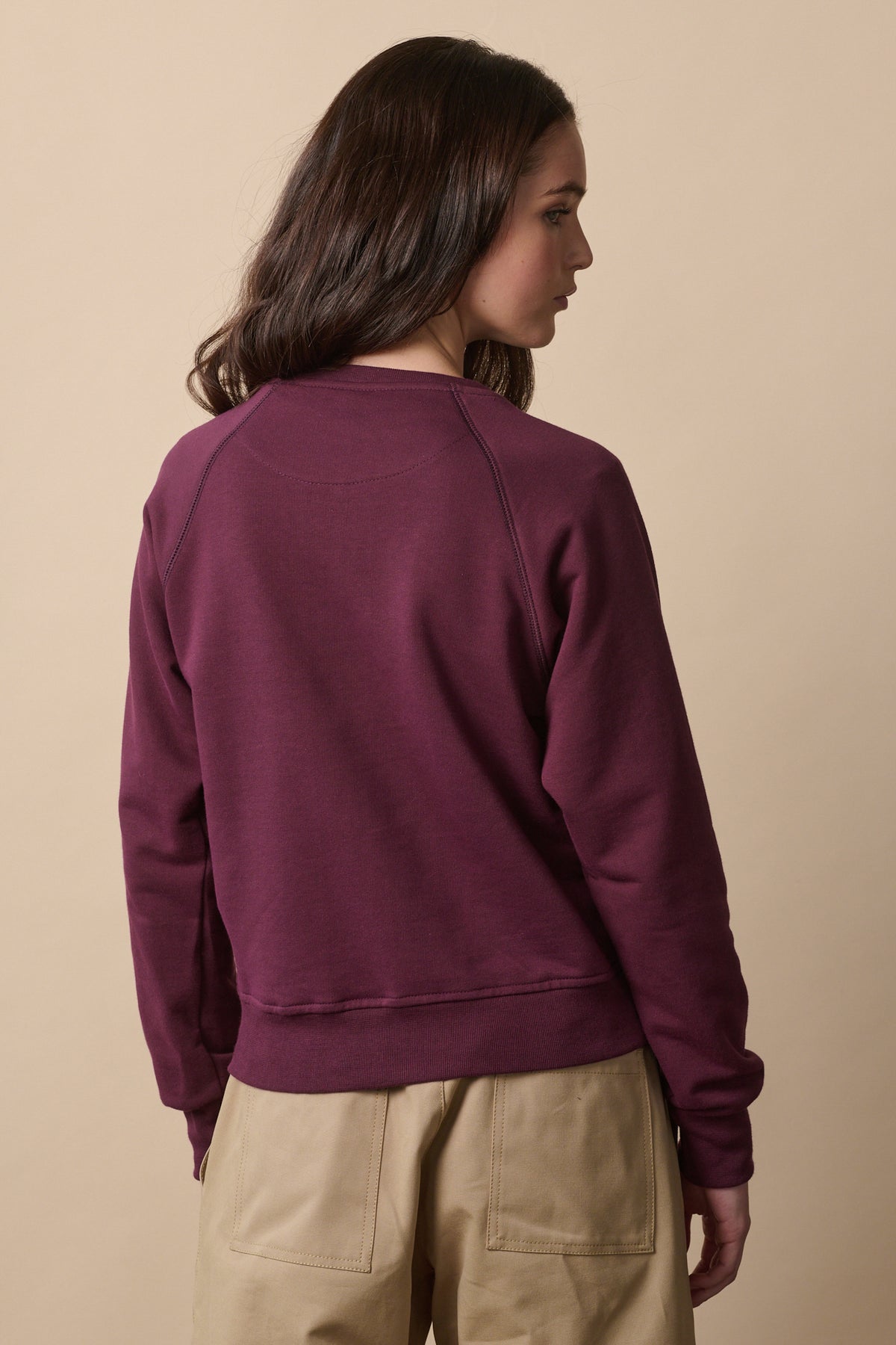 
            thigh up of the back of female wearing raglan sweatshirt in plum 