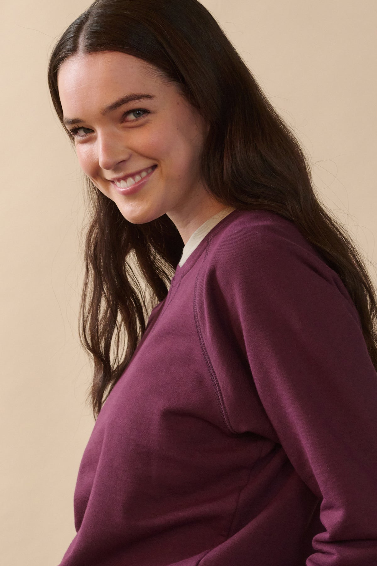 
            Waist up image from side of female wearing raglan sweatshirt in plum