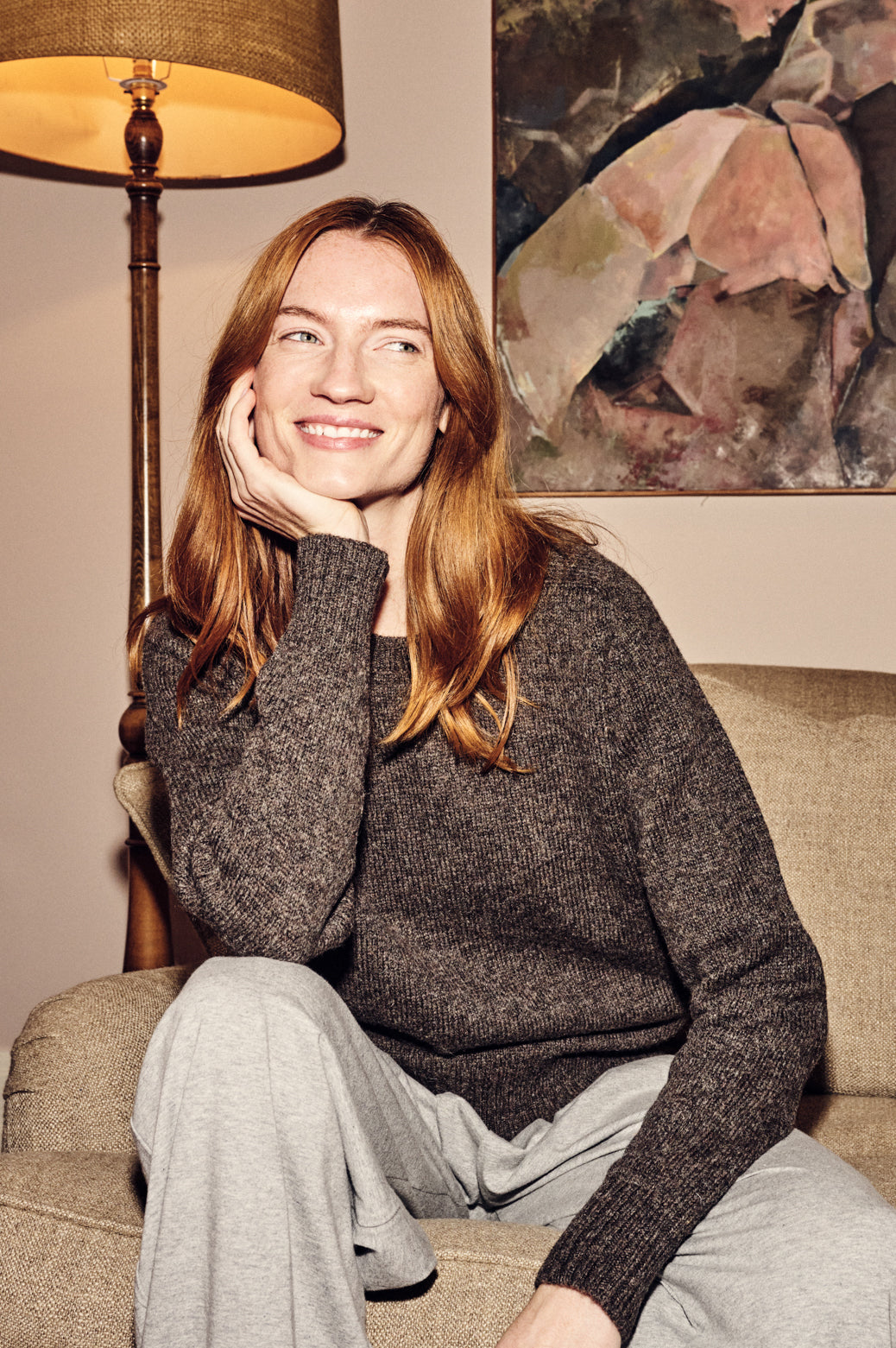 Smiley woman wearing brown shetland jumper sat of couch