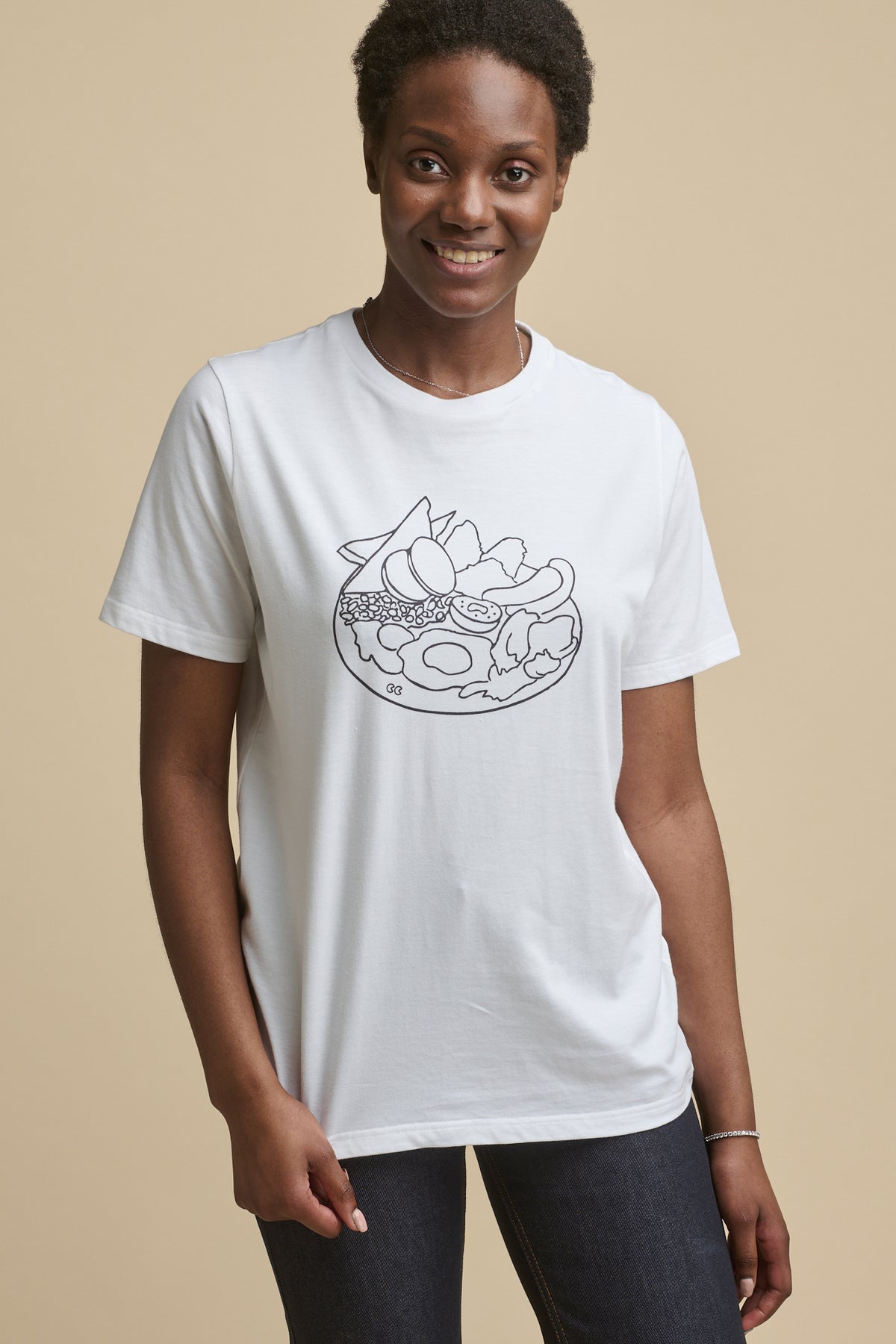 
            Thigh up image of smiley female wearing short sleeve graphic t shirt with full english print on the front