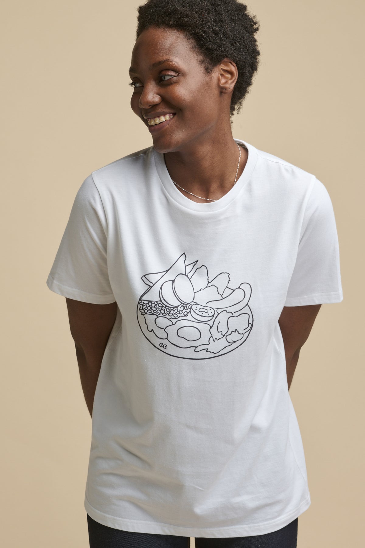 
            Thigh up image of smiley female wearing short sleeve graphic t shirt with full english print on the front 