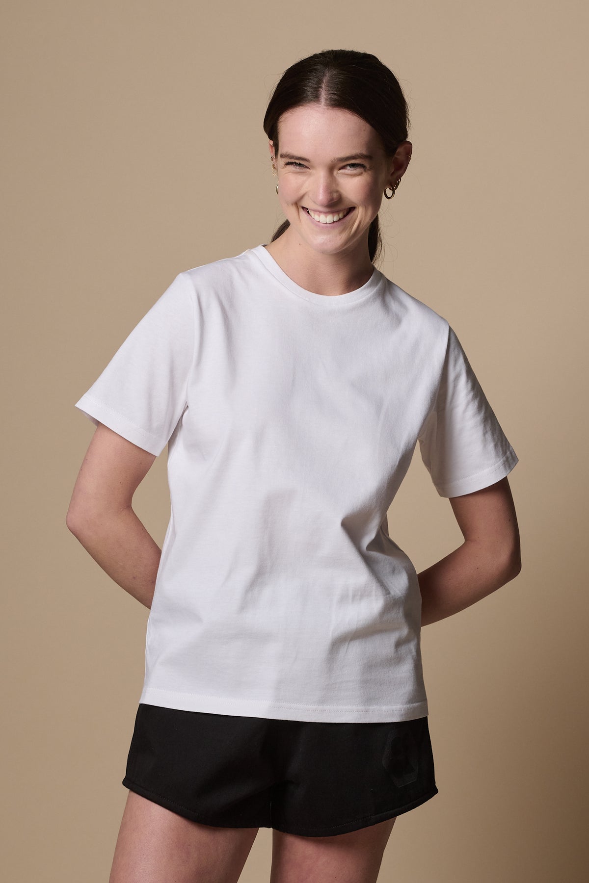 Smiley female facing the camera wearing women's short sleeve crew neck t shirt in white