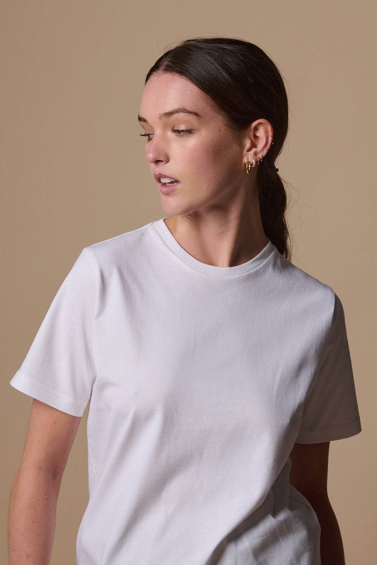 Waist up image of female wearing short sleeve t shirt plastic free in white with crew neck