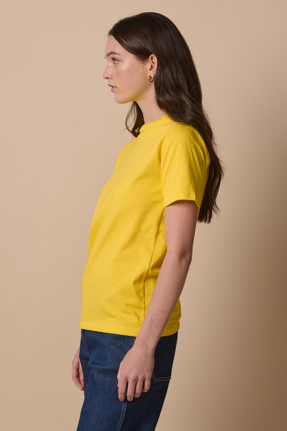 Thigh up image of the side of short sleeve t shirt in canary yellow