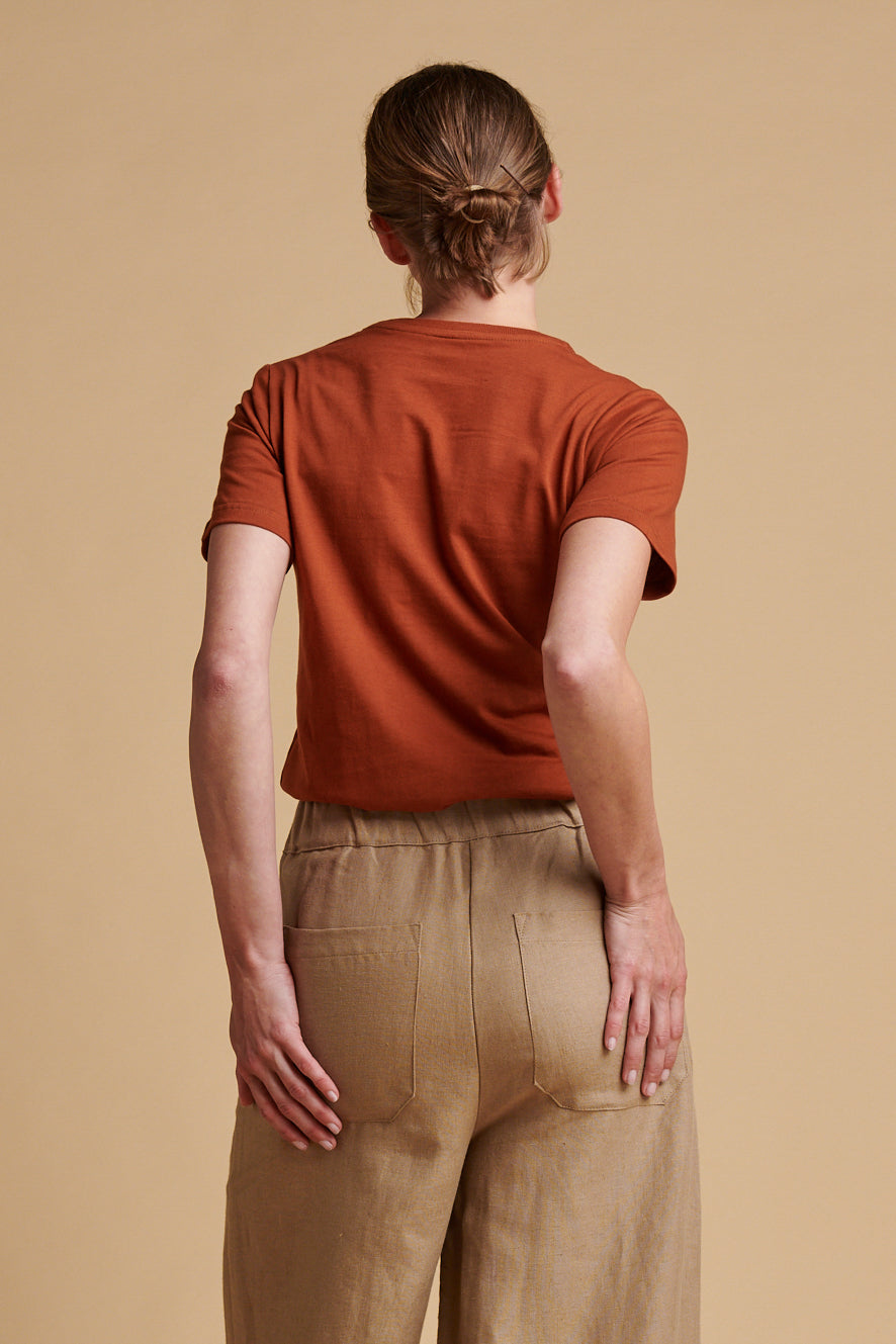 The back of female wearing short sleeve, crew neck t shirt in cinnamon.