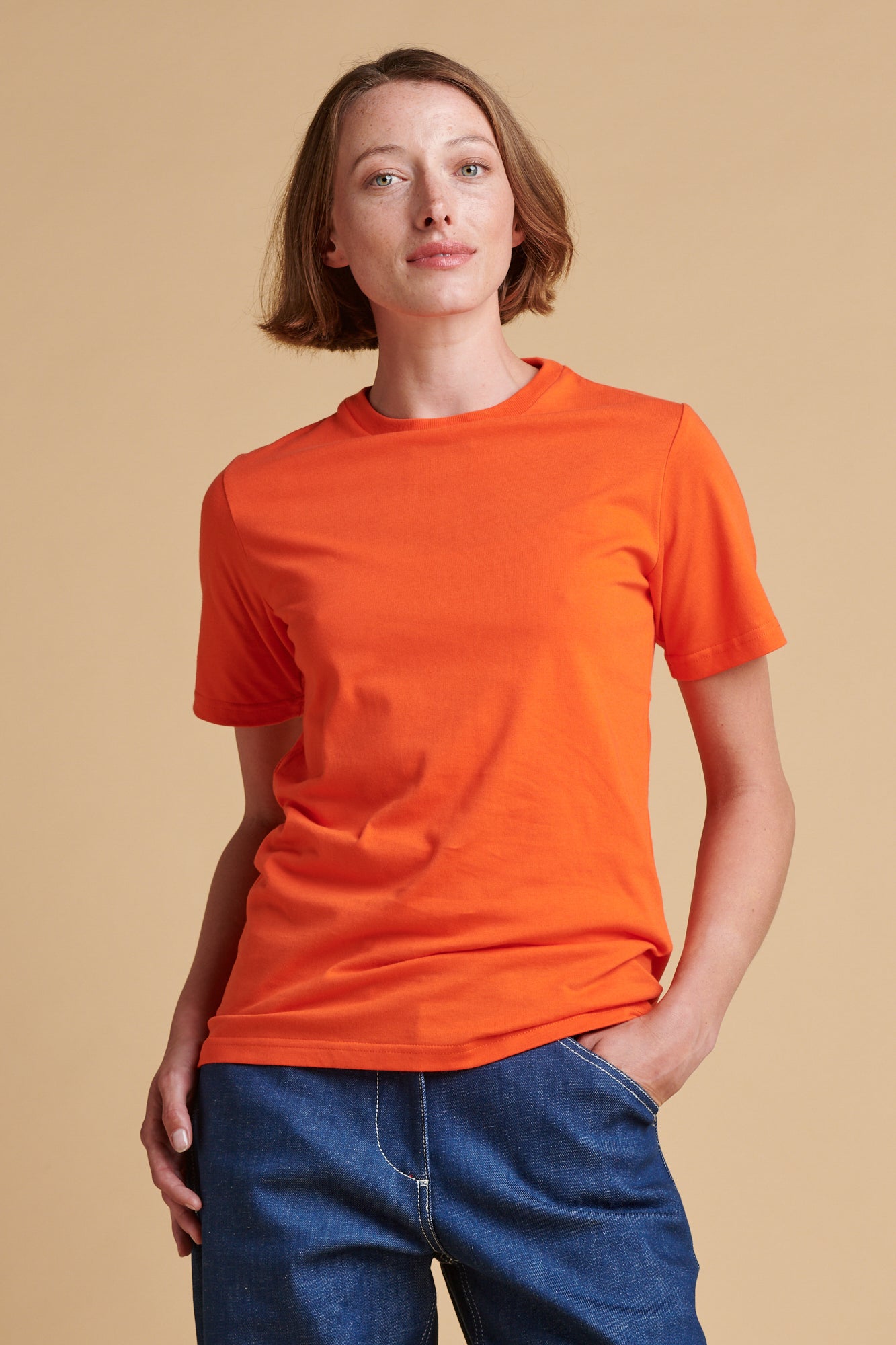 Female wearing short sleeve t shirt in flame red.