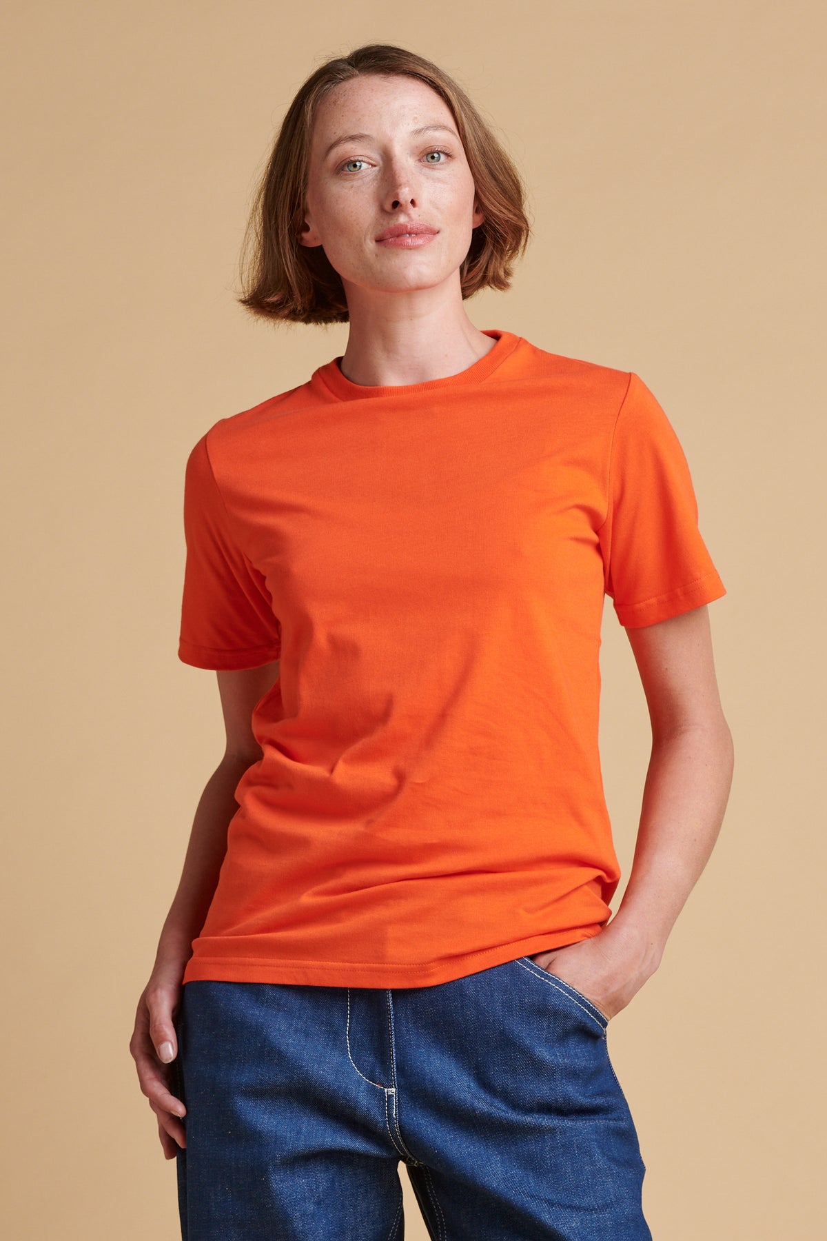 Female wearing short sleeve t shirt in flame red.