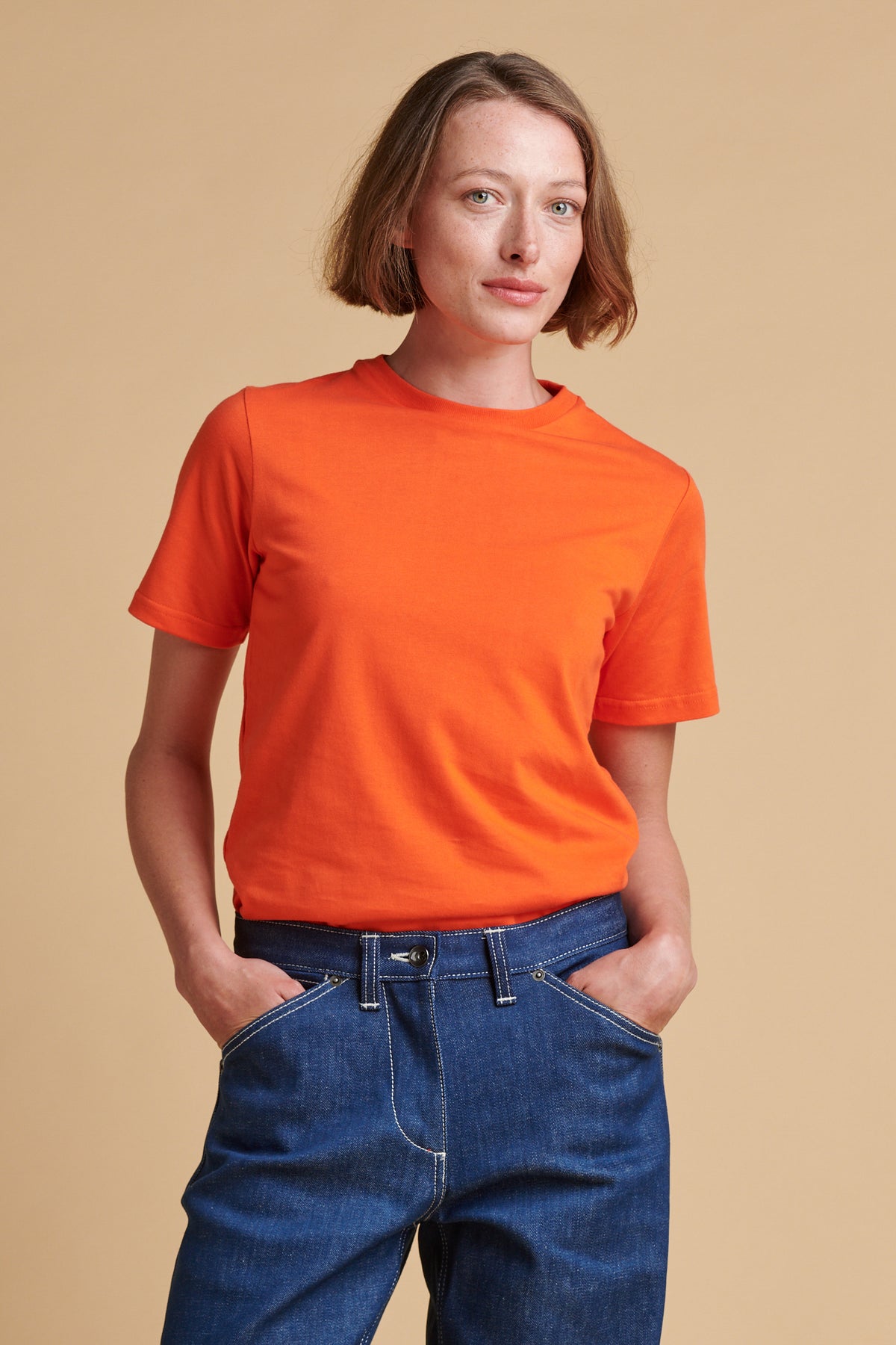 Female wearing short sleeve t shirt in flame red.