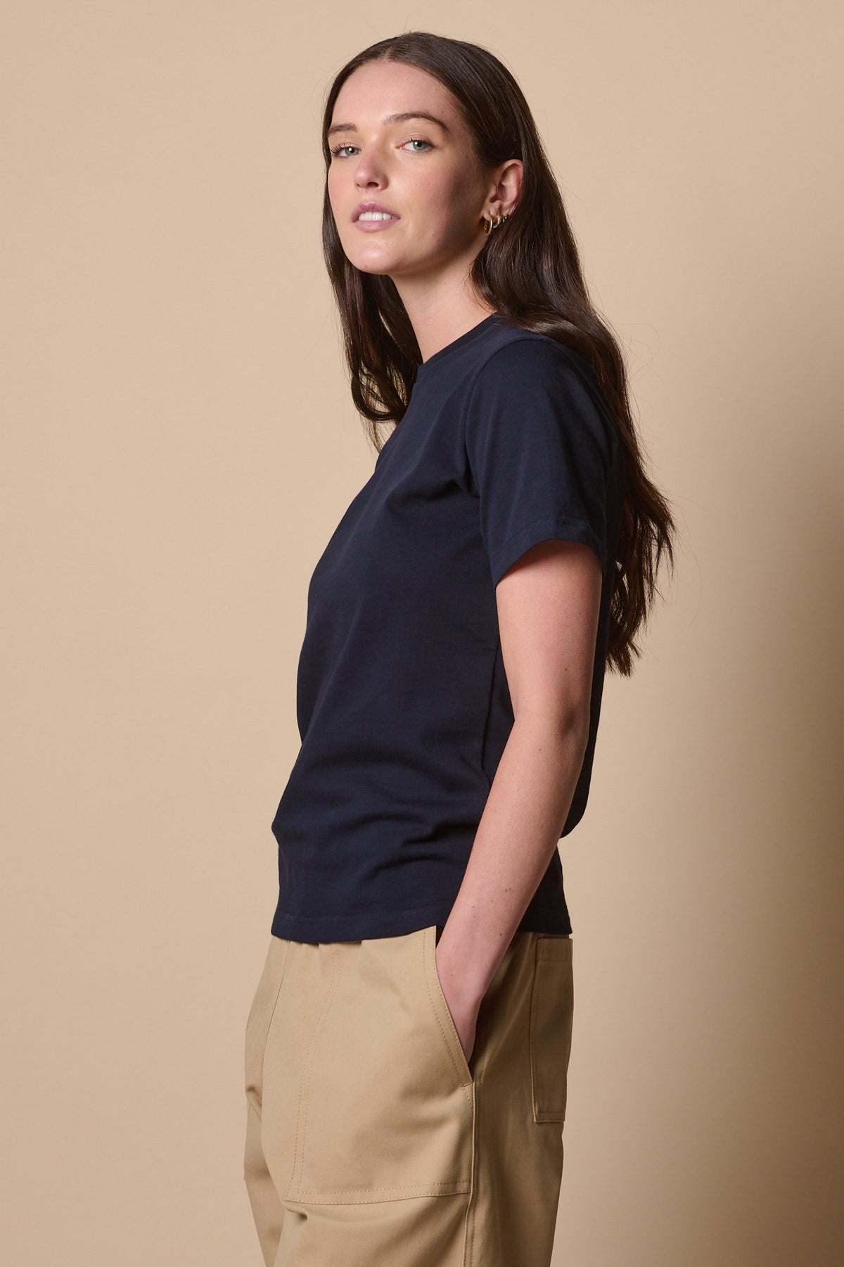 Thigh up image of the side of female wearing short sleeve t shirt in navy