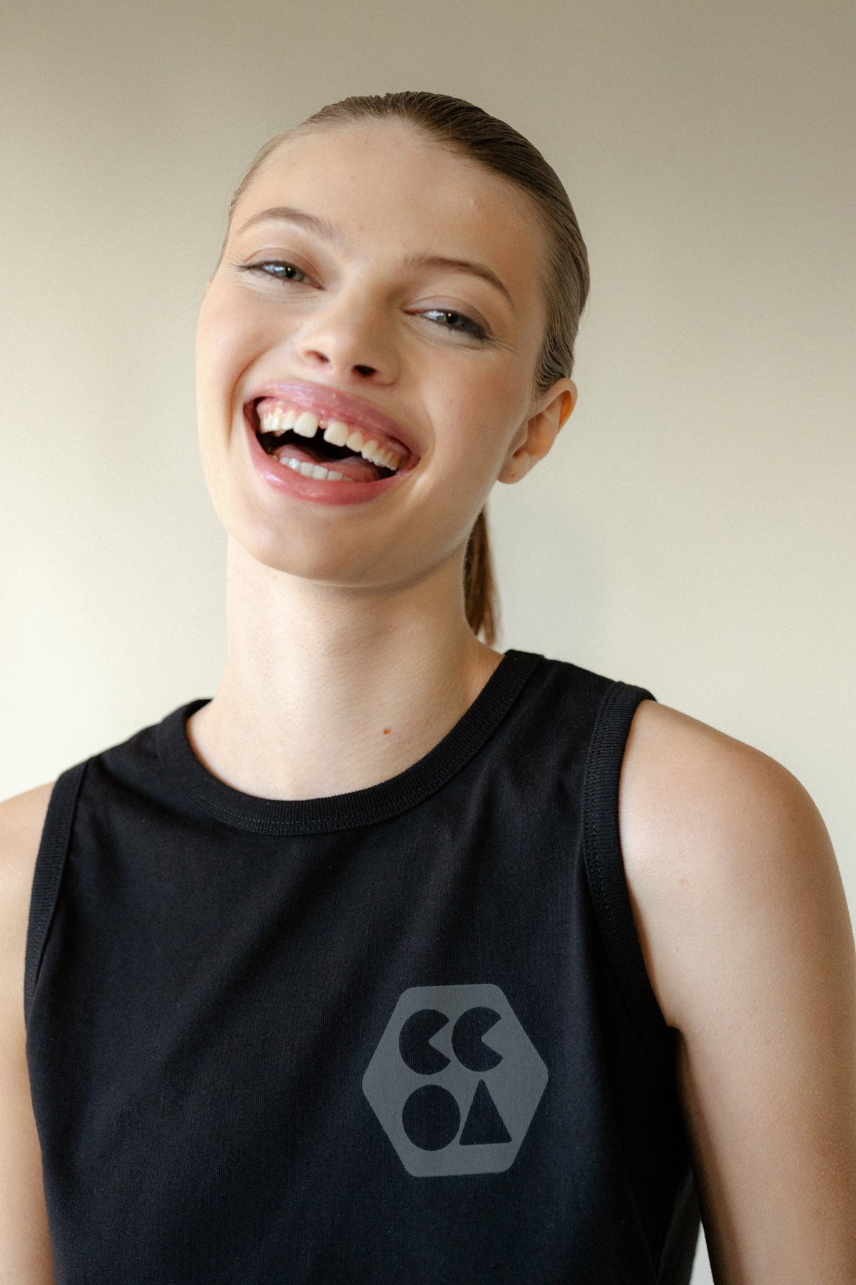 Portrait of smiley female wearing sleeveless t shirt in black with CCOA logo
