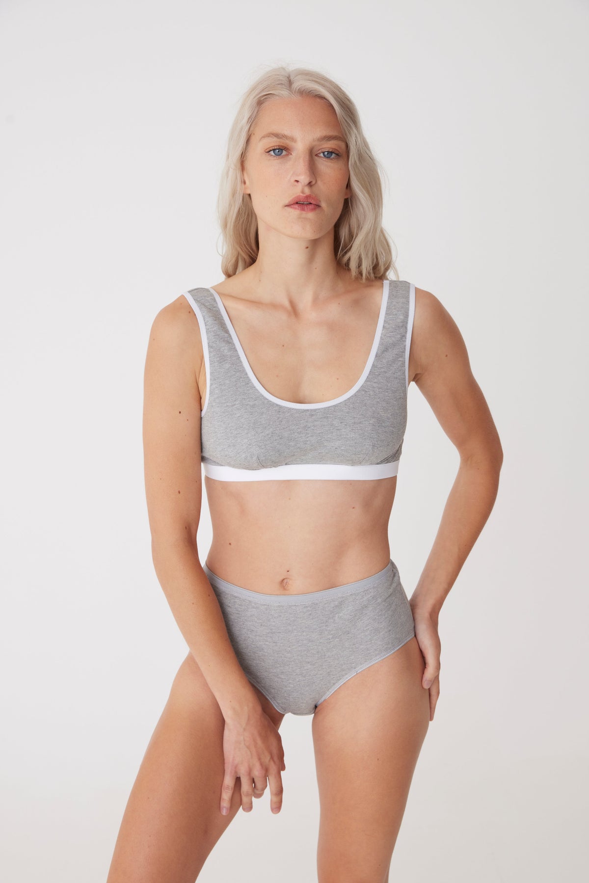 Blonde female in grey soft jersey bra with white contrast elastic paired with grey high rise briefs