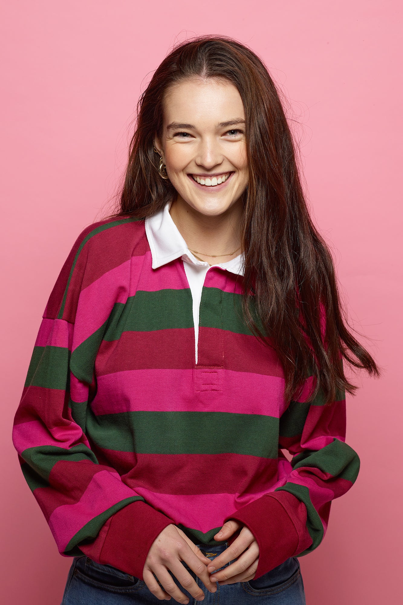 Brunette, female wearing unisex striped rugby shirt maroon, bottle green, cerise