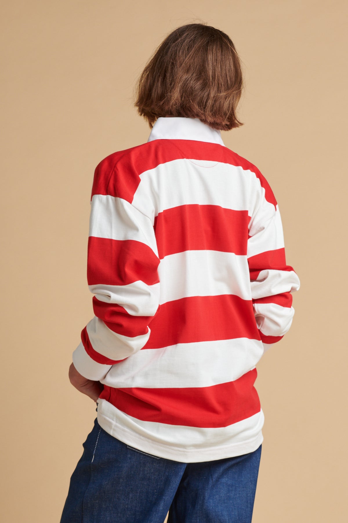 The back of female wearing unisex stripe rugby shirt in red and white.