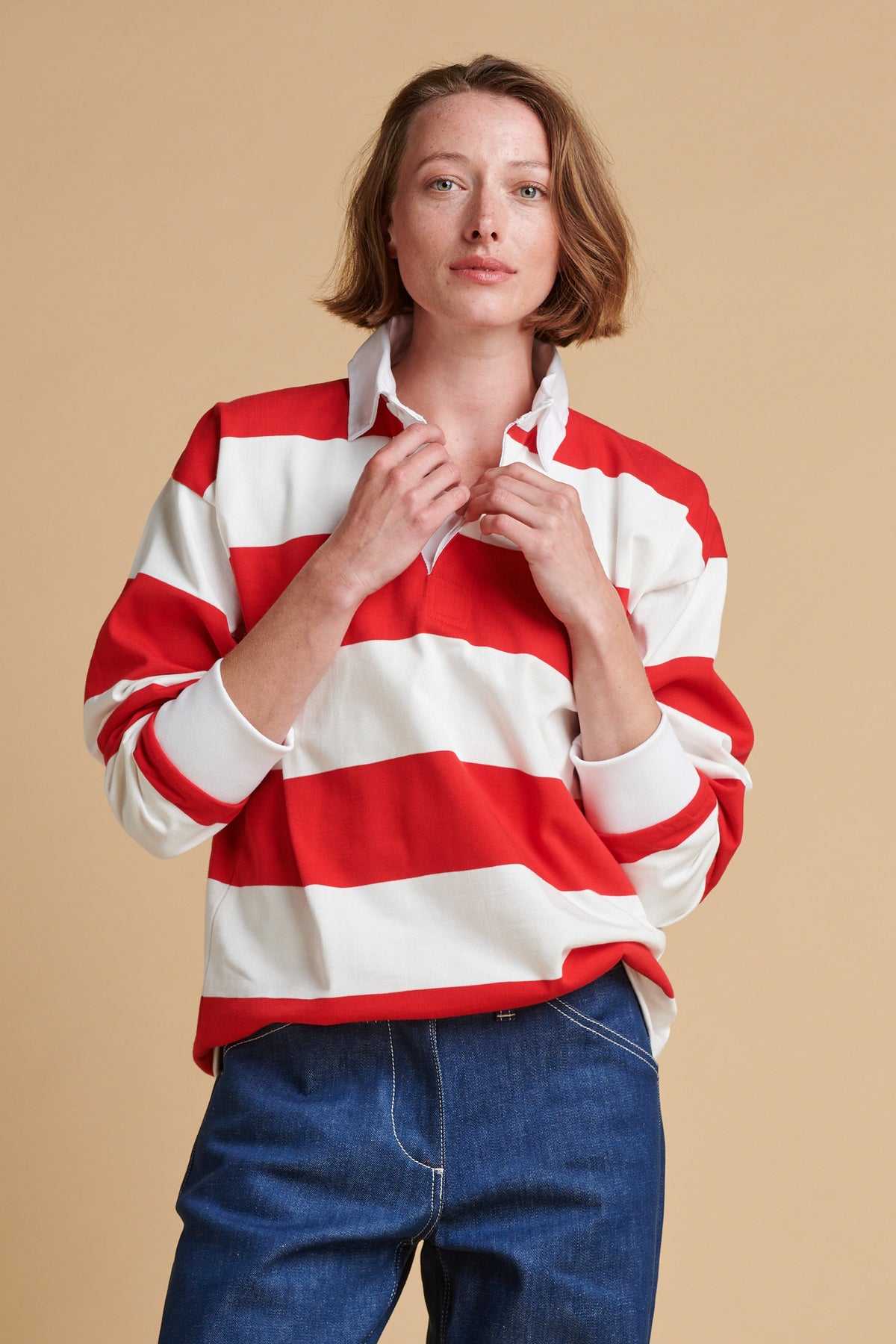 Female wearing unisex stripe rugby shirt in red and white.