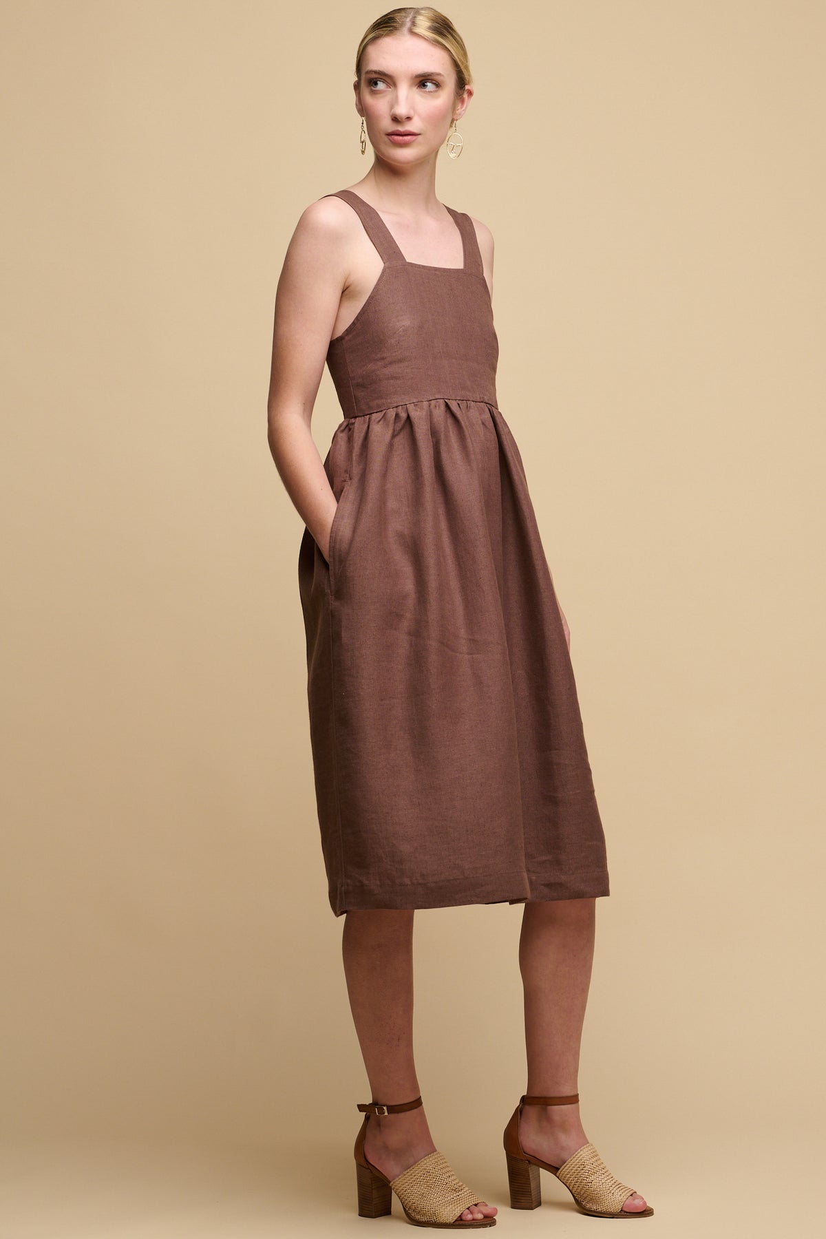 Full body shot of front of fair skinned female wearing sun dress in cocoa with her right hand in one of pockets