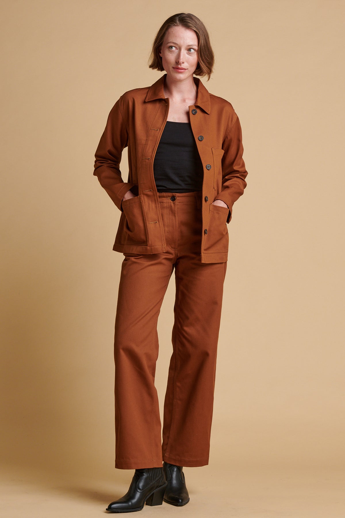 Female wearing twill work trousers in dark tan paired with black camisole.