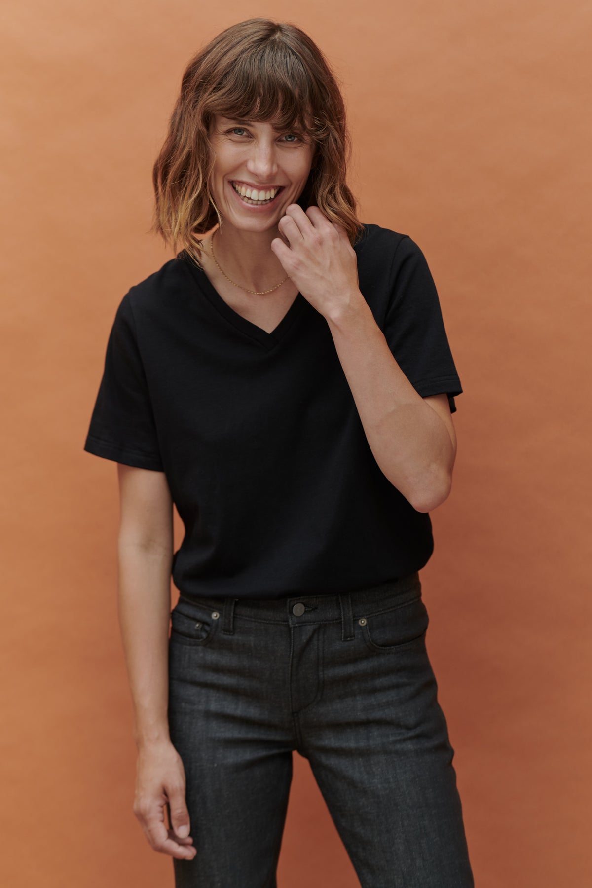 female wearing short sleeve v neck t shirt black thigh up front