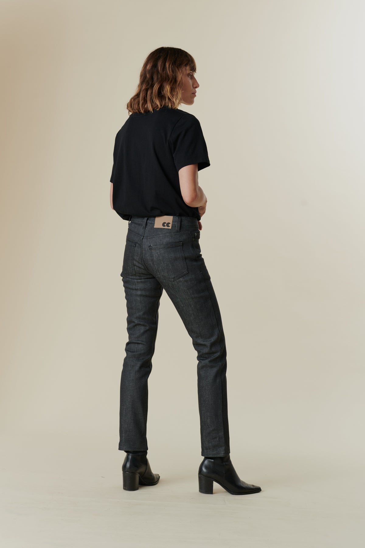 full body image of back of female wearing black v neck t shirt