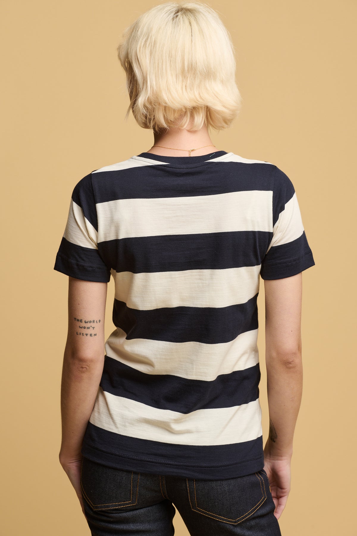 The back of female thigh up wearing short sleeve t shirt in ecru navy stripe
