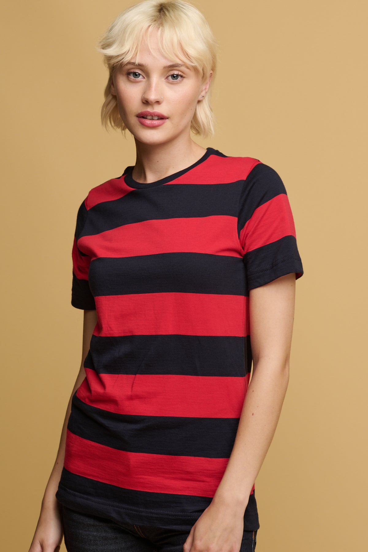 thigh up of the front of female wearing red and navy wide stripe short sleeve t shirt