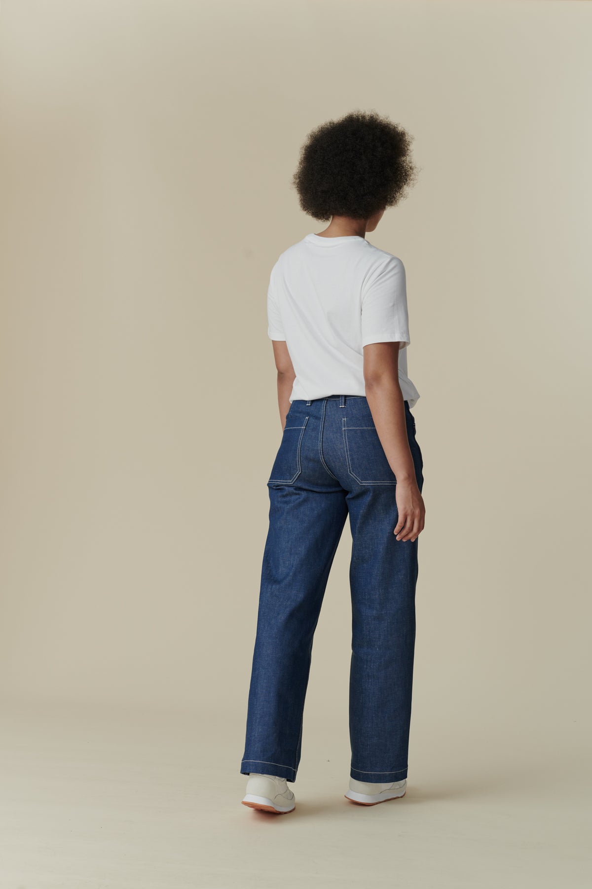 
            Female wearing white crew neck white t shirt paired with women&#39;s work jean in Blue, white contrast stitching