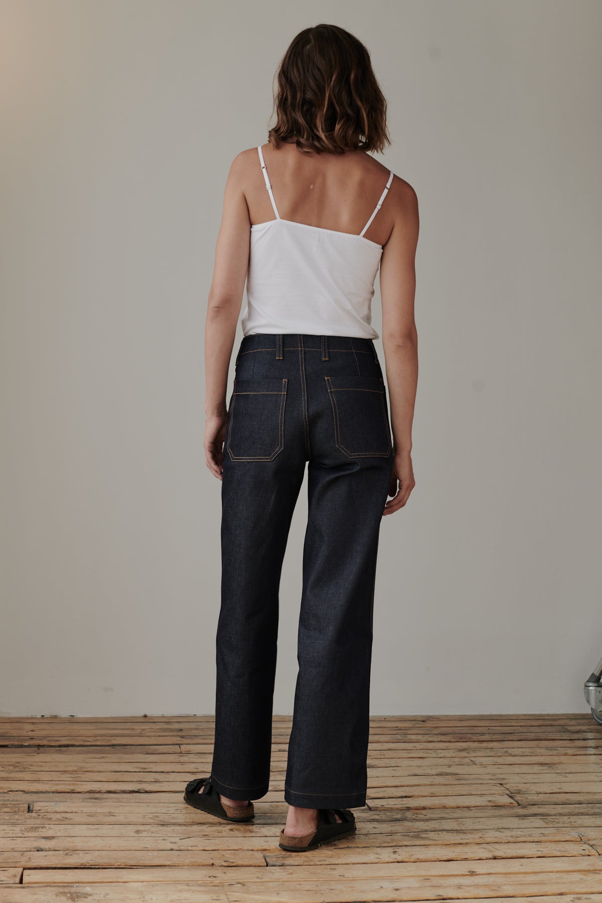 Full body image of behind of female wearing work jean indigo