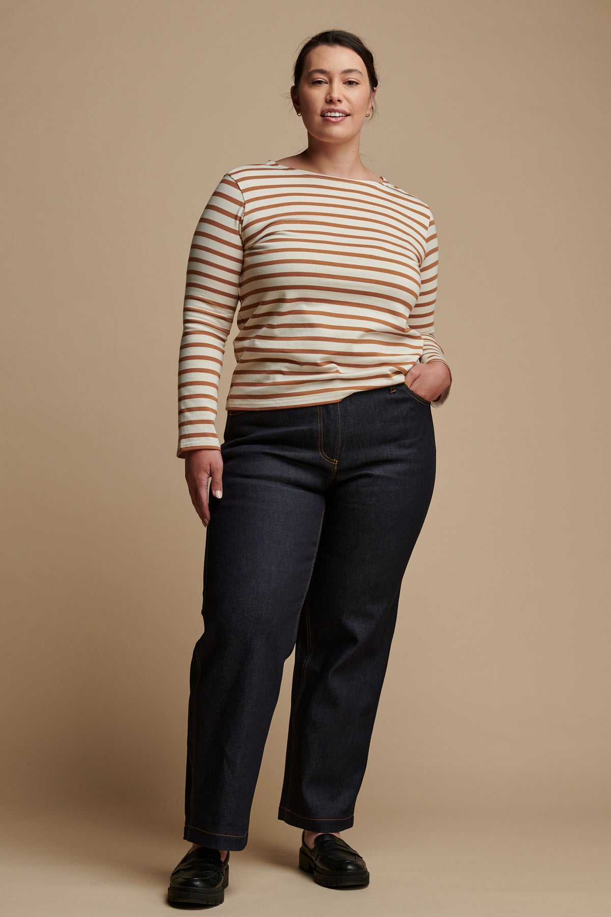 The front of female wearing work wide straight jean in indigo paired with Breton top in ecru-cinnamon.