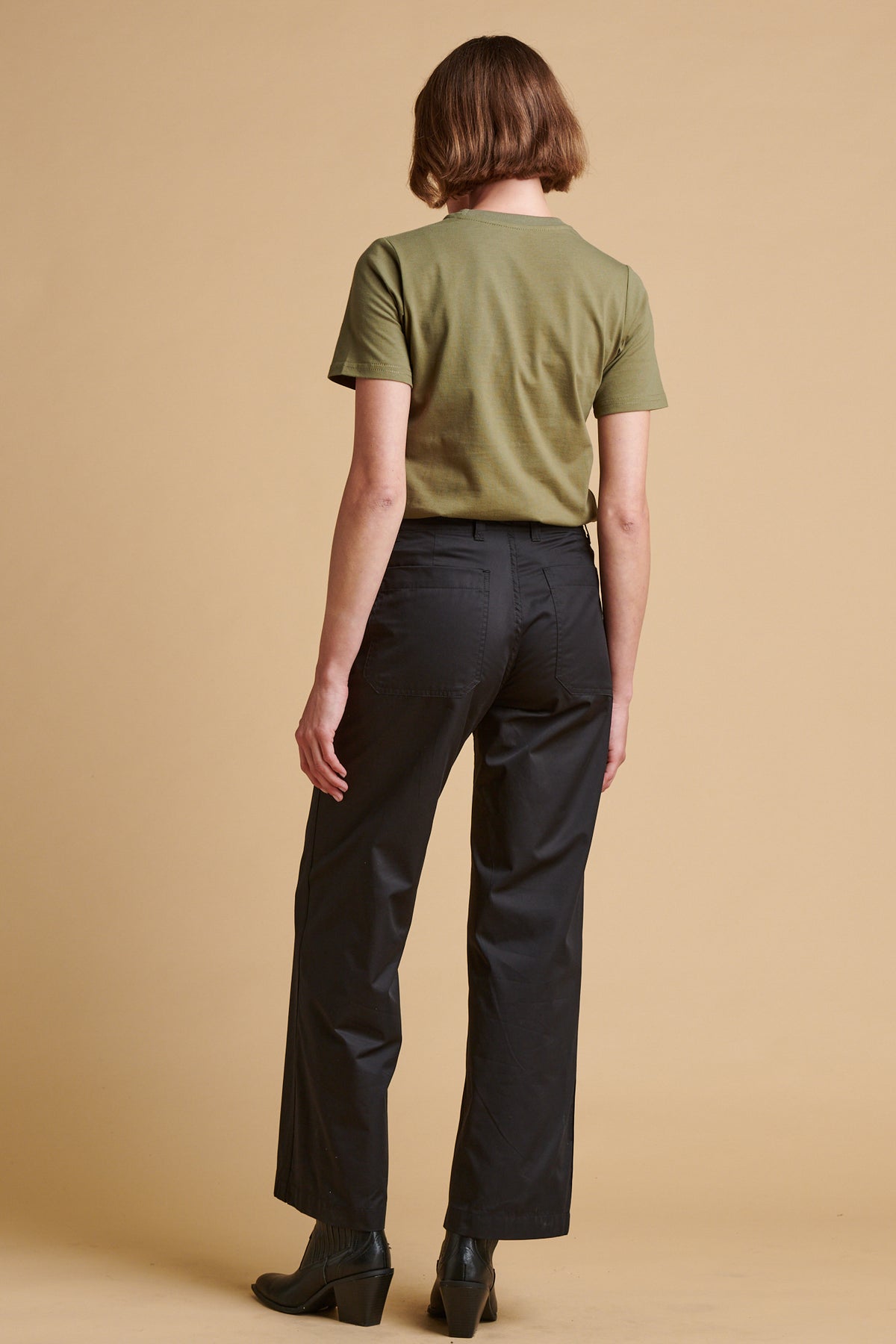 The back of female wearing lightweight work trousers in black.