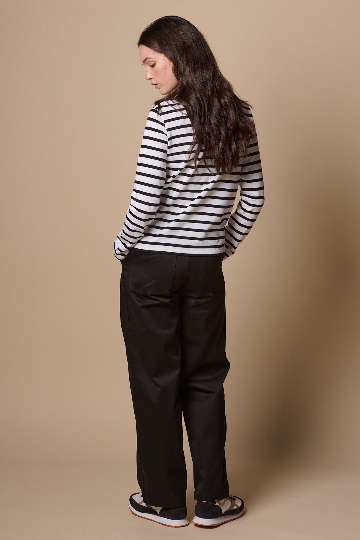 Image showing the back of brunette female wearing work trousers in black, two back pockets.