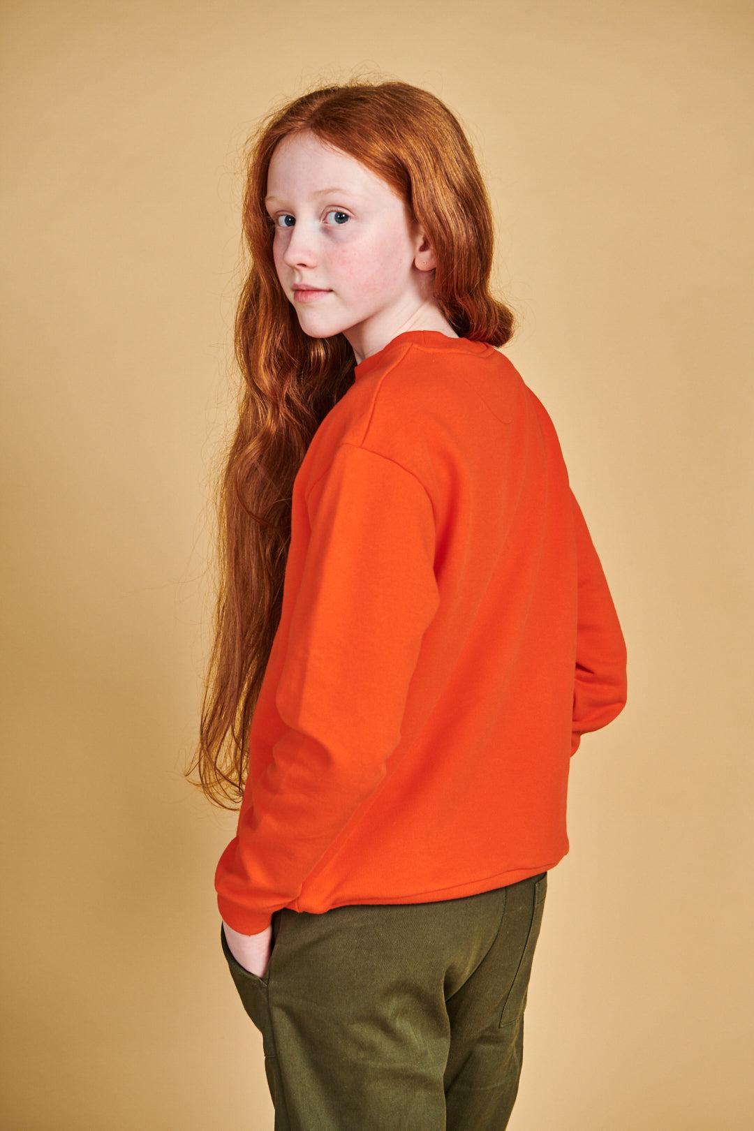 the back of girl wearing plastic free sweatshirt in flame red